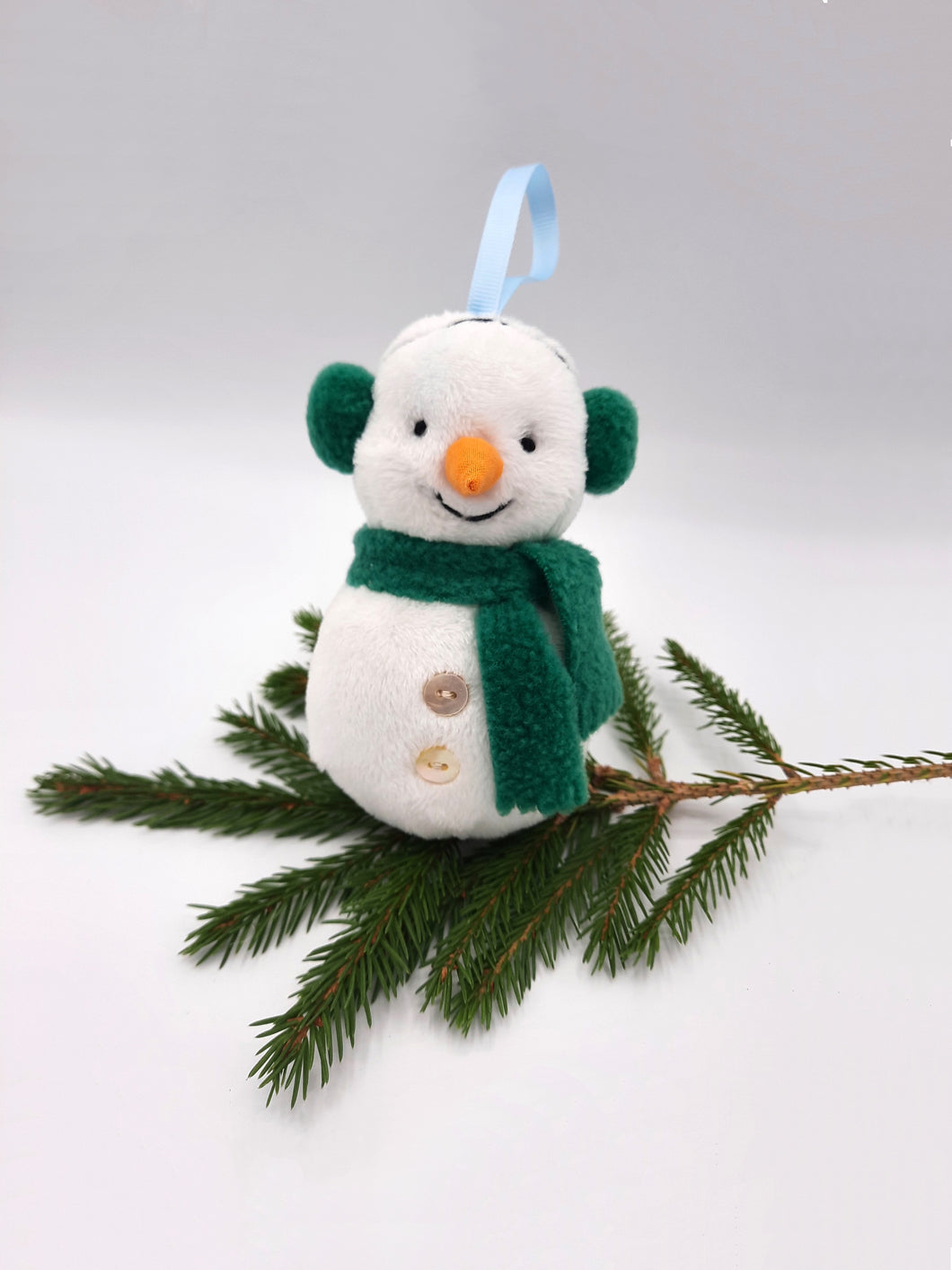 Hand made cute snowman Christmas tree decoration wearing fleece ear muffs and scarf.