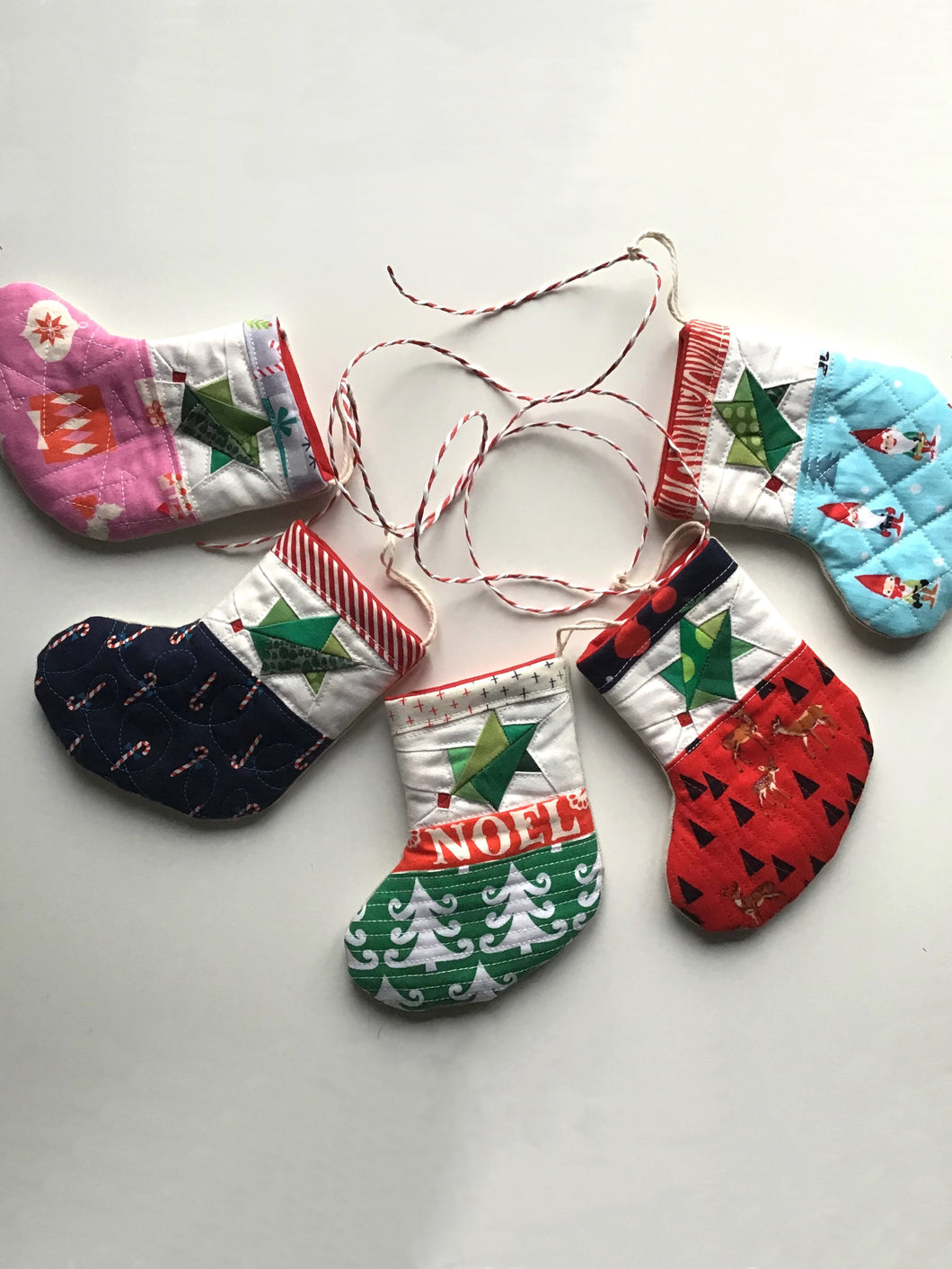 Handmade mini quilted Christmas stocking bunting with holly leaf design. 